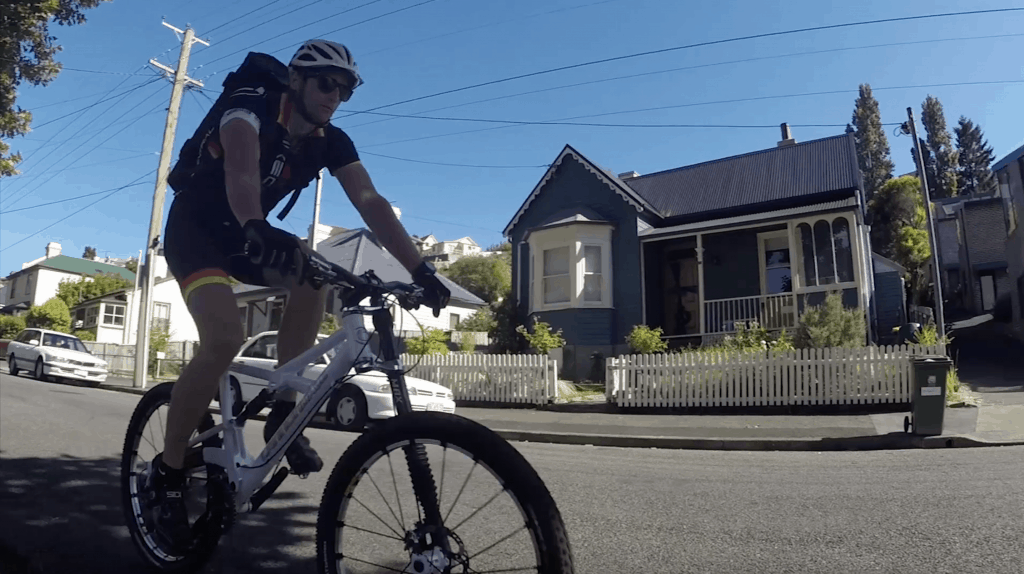 A man cycling down a Hobart street wearing the wingman backpack.