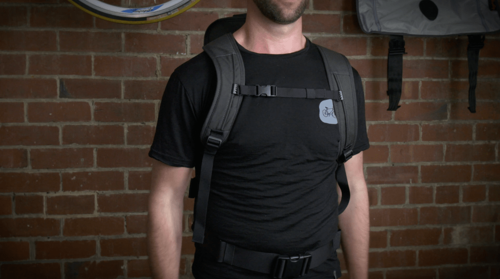 Mid-shot of a man in a black shirt wearing a black Henty pack.