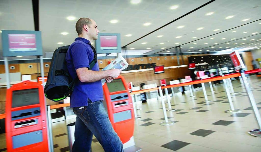 A man walking through airport wearing Henty travel garment bag